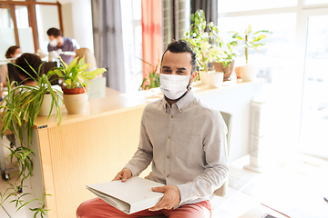 Image showing creative male office worker in mask with folder