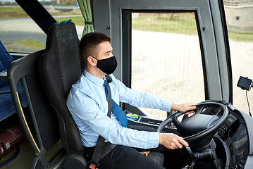 Image showing male driver in black mask driving intercity bus