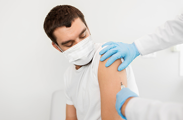 Image showing male patient in mask and doctor hands with syringe