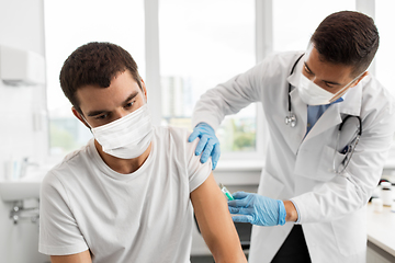 Image showing patient and doctor in masks doing vaccination