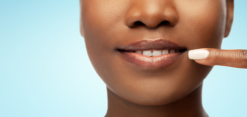 Image showing african american woman pointing to her mouth