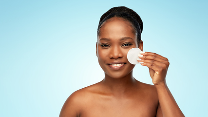 Image showing african woman cleaning face with cotton pad