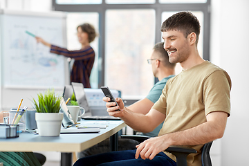 Image showing happy man with smartphone at office conference