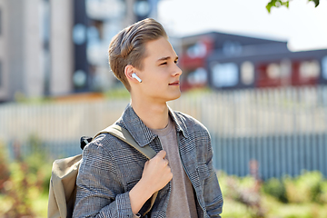 Image showing young man with earphones and backpack in city