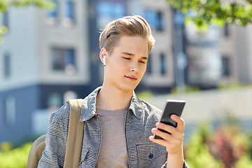 Image showing teenage boy with earphones and smartphone in city