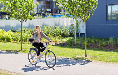 Image showing young man riding bicycle on city street