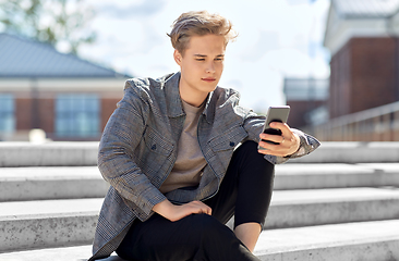 Image showing teenage boy using smartphone in city