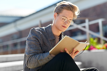 Image showing young man with notebook or sketchbook in city