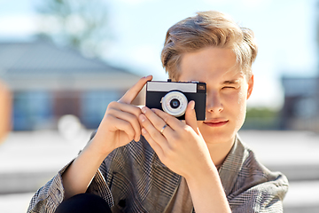 Image showing young man with camera photographing in city