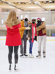 Image showing friends in masks taking photo on skating rink