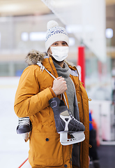 Image showing young man in mask with ice-skates on skating rink