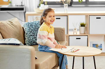 Image showing little girl drawing with coloring pencils at home