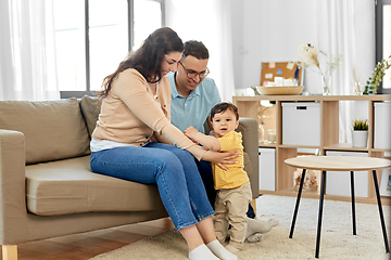 Image showing happy family with child sitting on sofa at home