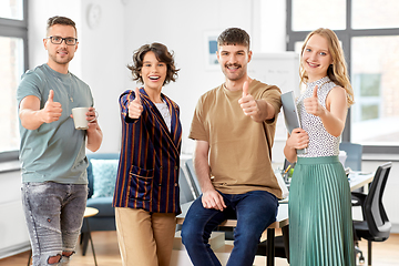 Image showing happy business team showing thumbs up at office