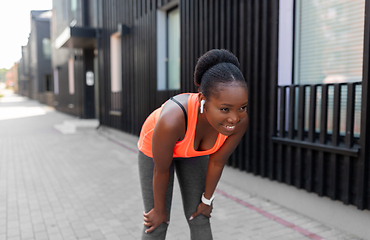 Image showing african american woman with earphones exercising