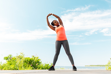 Image showing young african american woman exercising on beach