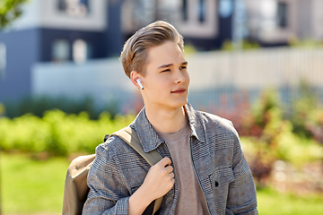 Image showing young man with earphones and backpack in city