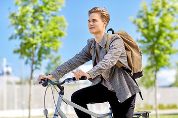 Image showing young man riding bicycle on city street