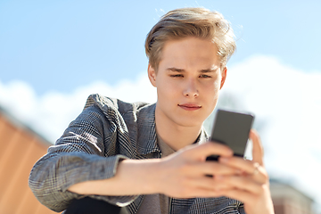 Image showing young man or teenage boy using smartphone outdoors