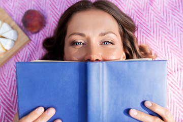 Image showing happy woman reading book at picnic in summer park