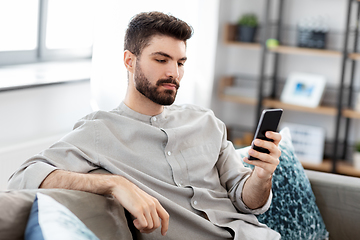 Image showing young man with smartphone at home