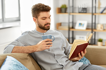 Image showing man reading book and drinking coffee at home