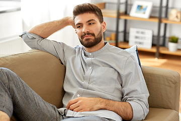 Image showing young man sitting on sofa at home