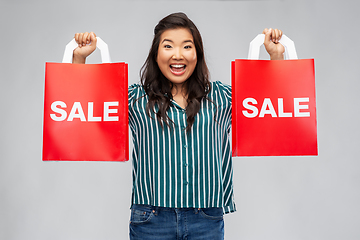 Image showing happy asian woman with shopping bags