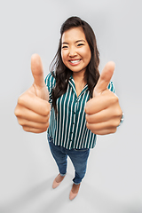 Image showing happy smiling asian woman showing thumbs up