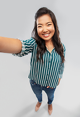 Image showing happy smiling asian woman taking selfie