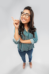 Image showing smiling asian student woman pointing finger up