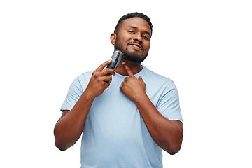 Image showing smiling african man shaving beard with trimmer