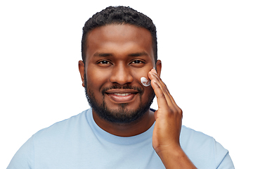 Image showing african american man applying moisturizer to face