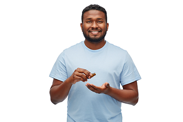 Image showing african man applying grooming oil to beard