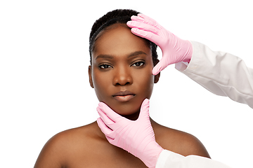 Image showing african american woman and hands in medical gloves