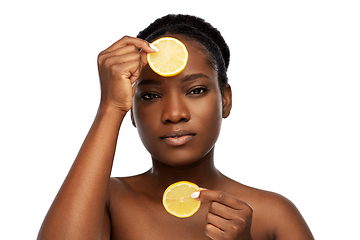 Image showing african woman making eye mask of lemons