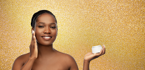 Image showing smiling african american woman with moisturizer