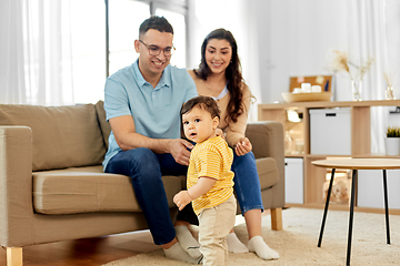 Image showing happy family with child sitting on sofa at home