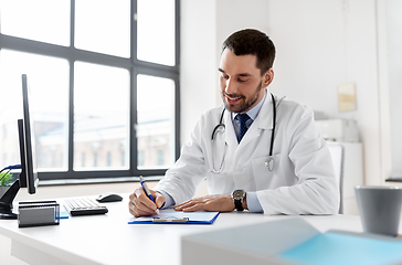 Image showing smiling male doctor with clipboard at hospital