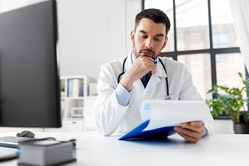 Image showing stressed male doctor with clipboard at hospital