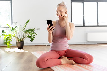 Image showing woman listening to music on phone at yoga studio