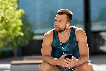 Image showing young athlete man with earphones and smartphone