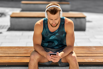 Image showing young athlete man with headphones and smartphone