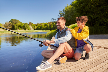 Image showing happy smiling father and son fishing on river