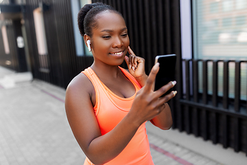 Image showing african american woman with earphones and phone