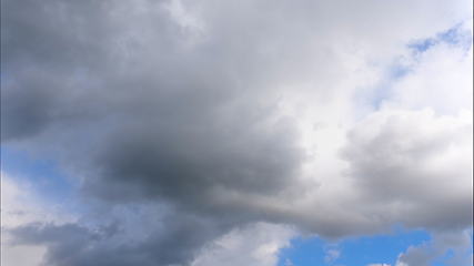 Image showing Time lapse Fluffy clouds float across the blue sky.