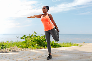 Image showing young african american woman exercising on beach