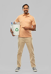 Image showing smiling young indian man sorting plastic waste