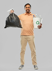 Image showing smiling indian man sorting paper and plastic waste