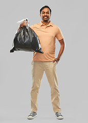 Image showing smiling indian man holding trash bag